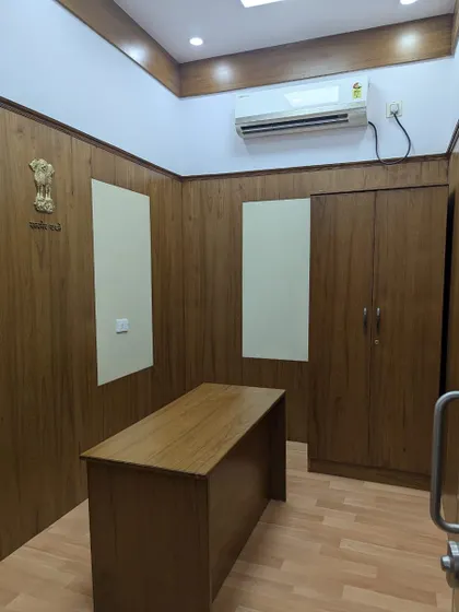 A completed office interior for a government building at Vidhana Soudha. The design is formal and functional, with clean lines, wood-paneled walls, and practical furniture suited for an official workspace.