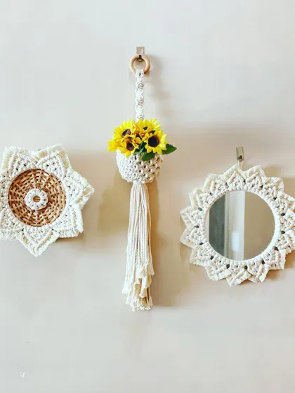 This wall arrangement shows how you can mix and match different pieces. It features a macrame mirror, a wicker-macrame medallion, and a mini hanging planter for a complete boho look.