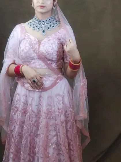 This pink lehenga is paired with a heavy blue and silver American Diamond necklace, creating a bold and beautiful contrast.