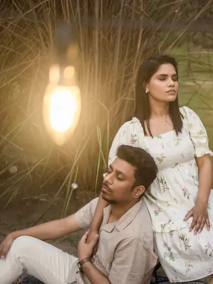 A close-up of the couple in a field, with a warm light bulb in the foreground creating a beautiful flare and a dreamy, magical effect.