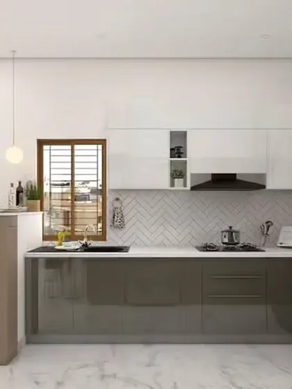 A compact breakfast bar transforms this kitchen into a multi-functional space for quick meals and morning coffee. The two-tone design with glossy grey lower cabinets and white uppers is complemented by a stylish herringbone backsplash.