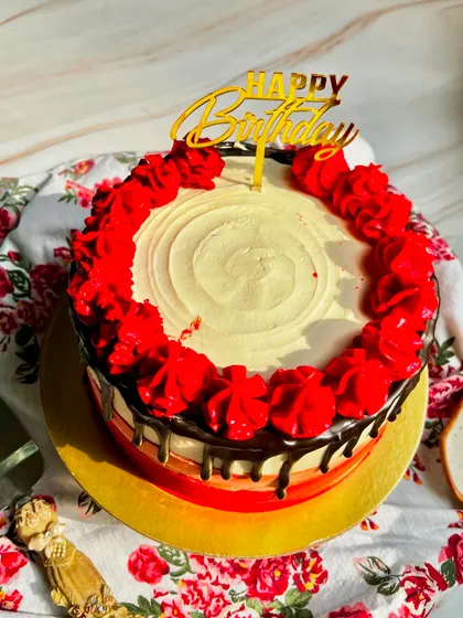 An overhead view of our Classic Chocolate Truffle Cake, showing the beautiful red piped roses and rich chocolate drip.