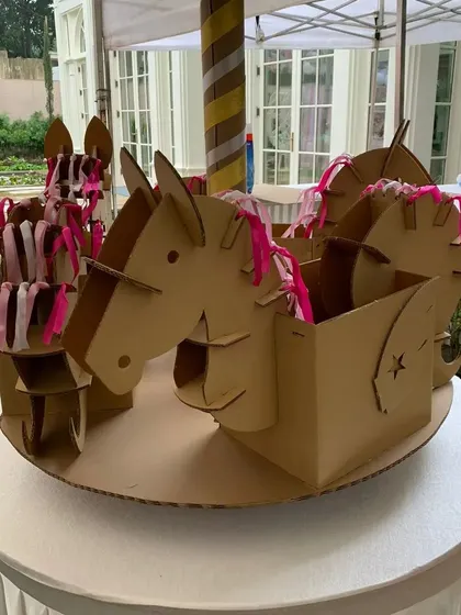 This view shows the detail of the carousel centerpiece, with individual cardboard horses decorated with pink ribbons. It's a perfect example of how I use simple, sustainable materials to create something truly special.