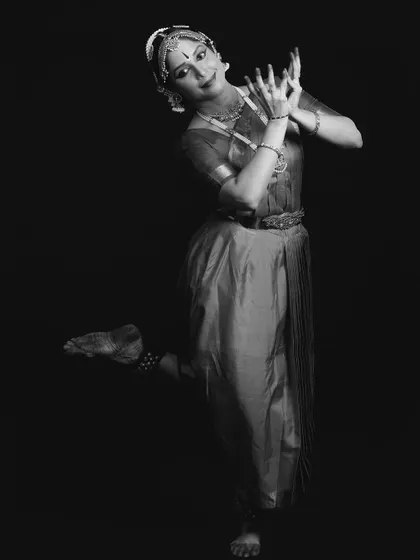 A full-body black and white portrait of Ambili Krishnan, capturing her elegance and poise.