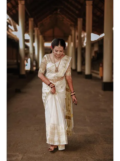 A graceful shot of the bride walking through a temple corridor.