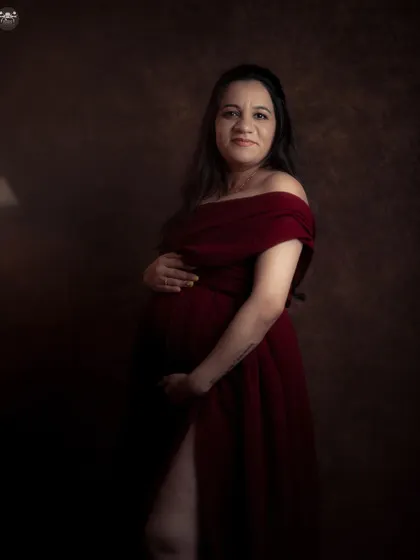 A direct and confident pose in a stunning red maternity gown. This style of portraiture is perfect for clients who want bold, striking images that feel both powerful and personal.