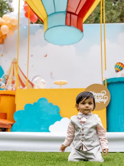 A candid shot of the birthday boy in front of the colorful hot air balloon backdrop. We focus on creating magical settings that spark imagination.