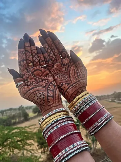 A perfect sunset shot showing off the gorgeous henna stain. The rich color of the mehndi against the warm light is just magical, especially with the bridal chura.