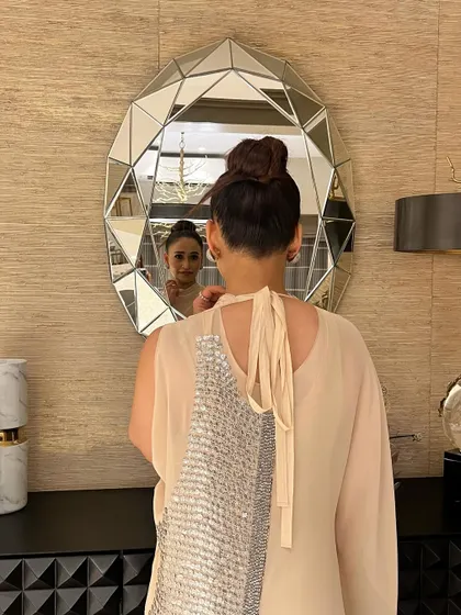 I love this creative shot showing the back of the top knot in the mirror. It’s a perfectly neat and structured bun that is timelessly chic.