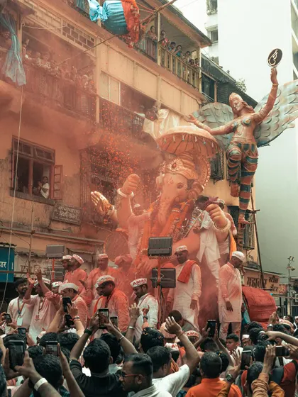 The streets of Mumbai during Ganpati Visarjan. The air is thick with color, music, and devotion as the massive idol makes its way through the crowded streets.