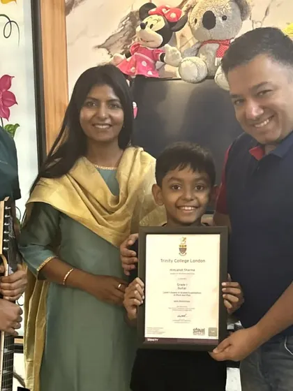 **A Musical Family.** This family is all in on the musical journey. We love seeing parents support their children's passion, with this young champion holding his certificate, ready for the next step.