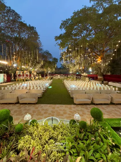 An enchanting outdoor evening setup, where strings of fairy lights hang like a canopy of stars over elegant guest seating, creating a truly magical and romantic atmosphere for your celebration.