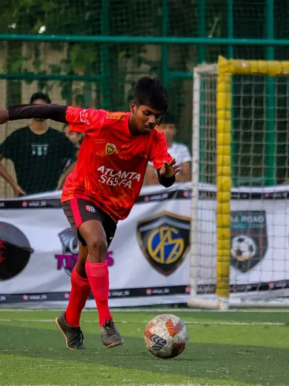 A player in our red Atlanta SG5FA kit dribbling the ball during a 2-0 victory against Toman FC.