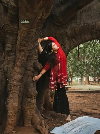Using a tree for support in a standing backbend, connecting with the grounding energy of nature.