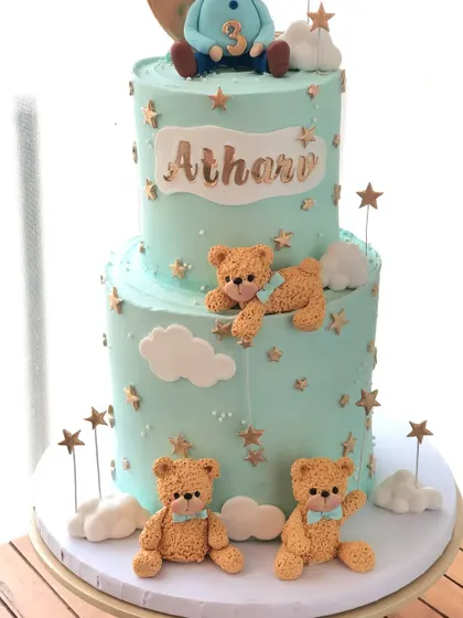Another angle of the dreamy two-tiered teddy bear cake, showcasing the soft colors and golden details.