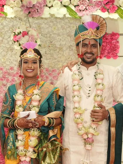 The happy couple posing for a photo. I work to create a bridal look that photographs beautifully, capturing the joy and tradition of your Maharashtrian wedding.