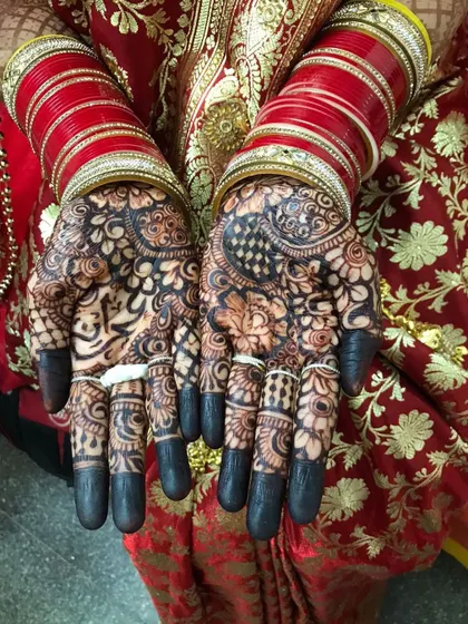 The rich henna stain looks beautiful with the traditional red bridal bangles (chooda).