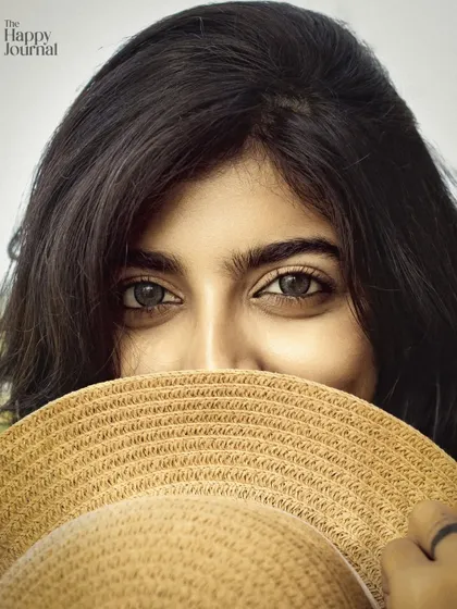 This is a close-up portrait where the eyes tell the story. The composition, with the hat partially covering her face, draws all the attention to her expressive eyes, making for a captivating and memorable branding photo.