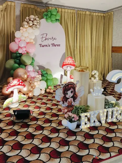 A different take on the fairy theme, this setup for a third birthday uses a clean, arched backdrop and a pastel balloon color palette.