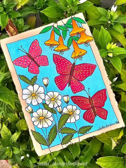 A painting of red butterflies and flowers on handmade paper, nestled amongst real green leaves. This piece was a handmade birthday gift for a dear friend.