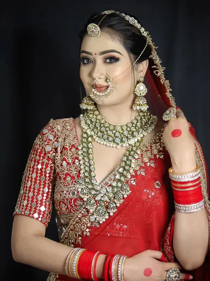 A close-up on the detailed jewelry and makeup of a traditional Indian bride. Our curriculum includes lessons on how to complement heavy bridal attire and jewelry with the right makeup.