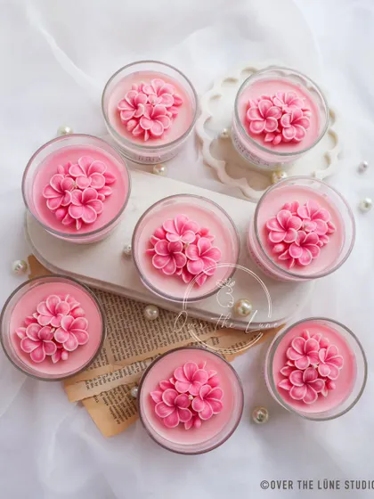 An overhead shot of the custom Plumeria bridal shower candles. The arrangement of the flowers in each jar is done with so much care.