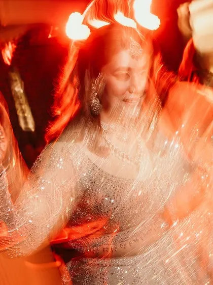 An artistic and abstract shot of a guest on the dance floor, with red light trails creating a sense of energy and movement.