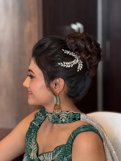 A side profile of the textured updo, highlighting the soft, face-framing tendrils and the placement of the hair accessory.