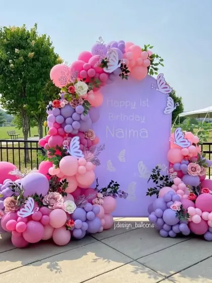 I can bring your party vision to life in any outdoor setting. This first birthday party features a beautiful pastel balloon arrangement in shades of pink, purple, and white with butterfly and flower accents, all set against a custom backdrop for a lovely garden party feel.
