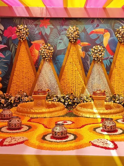 This image focuses on the floor decor for the Haldi ceremony, with floral rangoli patterns made from marigold petals and traditional pots for the rituals.