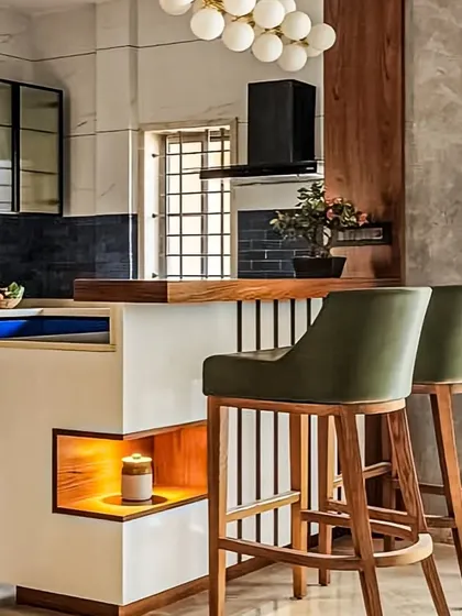 We designed this kitchen with a breakfast counter that doubles as a space divider. The combination of dark blue cabinets, a white and wood counter, and olive green bar stools creates a stylish, contemporary look.