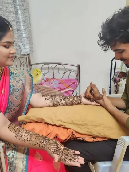 Applying mehandi for a client in a beautiful pink saree.