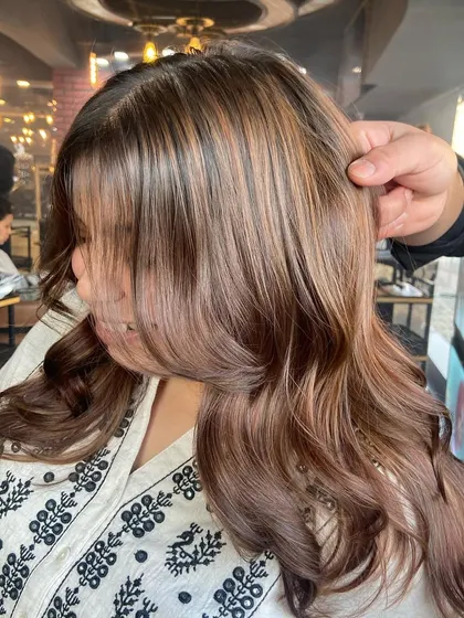 A side profile of the honey-caramel balayage, highlighting how the colors frame the face and blend seamlessly.