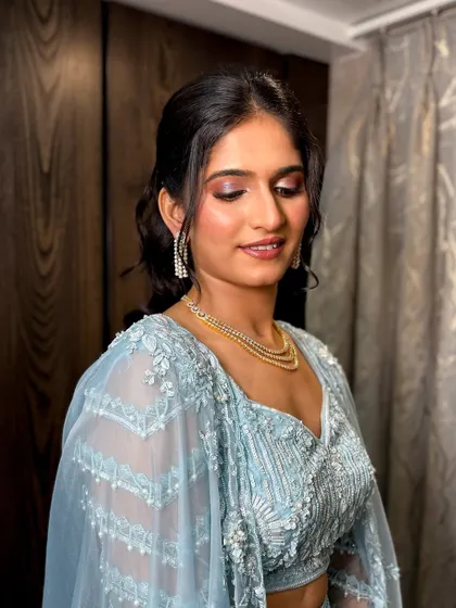 A stunning sangeet look in a pastel blue lehenga, with shimmery purple and pink eyeshadow.