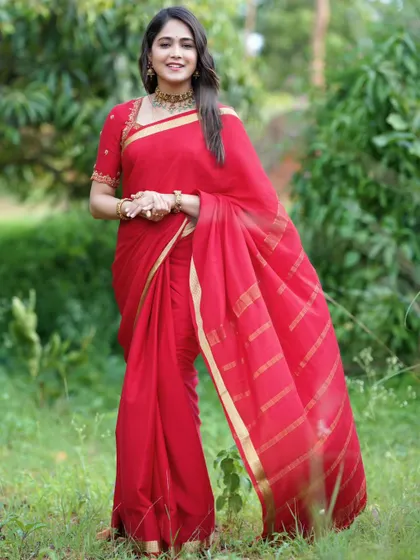 The full drape of the red saree, showing the elegant gold border.