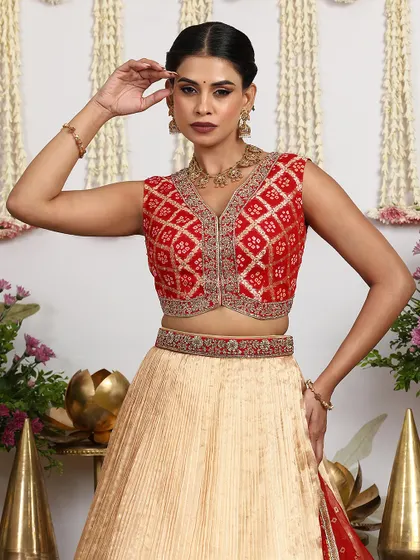 The model's pose captures the confident and graceful spirit of the Sindhu Reddy woman, wearing our beige and red lehenga set.