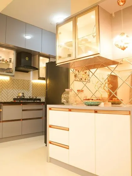 A view of the open-plan living and kitchen area, highlighting the breakfast bar with a diamond-patterned mirror backsplash. This feature adds a touch of glamour and reflects light beautifully.