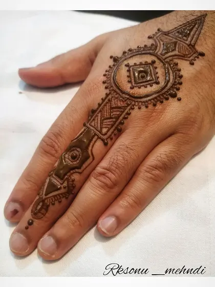Proving that mehndi knows no gender, this design is a bold and artistic choice for a man's hand. It shows that intricate patterns can be adapted to create a strong, masculine look.