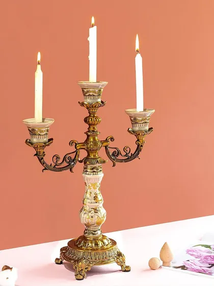 This classic candelabra combines an antique brass finish with floral-painted ceramic accents. It's a perfect centerpiece for a formal dining table, bringing a touch of old-world charm to your gatherings.