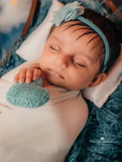 A close-up of this sleeping beauty. Her peaceful expression and tiny hand gesture make this a truly heart-melting newborn portrait.