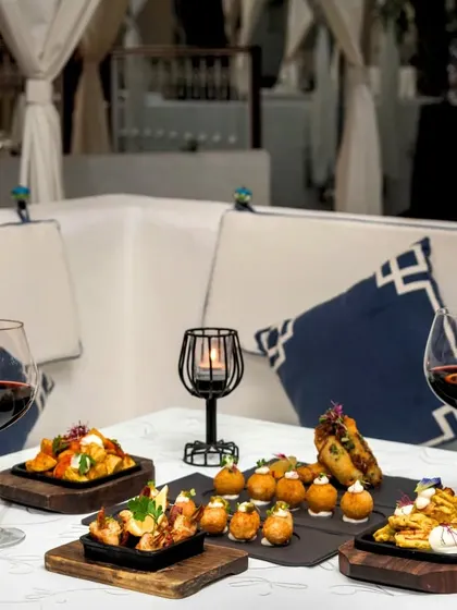 A beautiful arrangement of tapas set up in one of our cozy cabanas. This image captures the social and relaxed spirit of sharing small plates.
