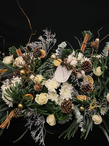 A serene, winter wonderland-inspired centerpiece. I married the purity of white blossoms with natural green foliage, pinecones, and dried oranges to evoke the stillness of a misty winter's walk.