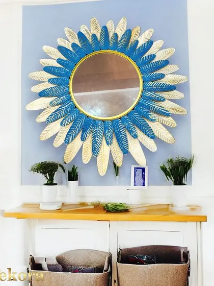 A sunburst mirror with a twist, featuring dual-toned leaves in a vibrant blue and gold. This piece is perfect for adding a pop of color to your wall.