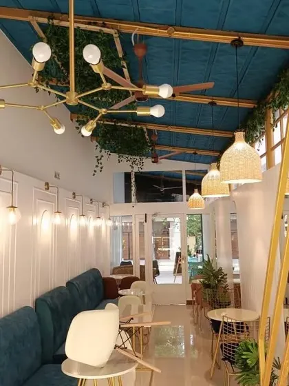 We believe lighting fixtures should be both beautiful and functional. This shot highlights the interplay between the statement chandelier, the rustic woven pendants, and the elegant wall sconces that define the cafe's sophisticated aesthetic.