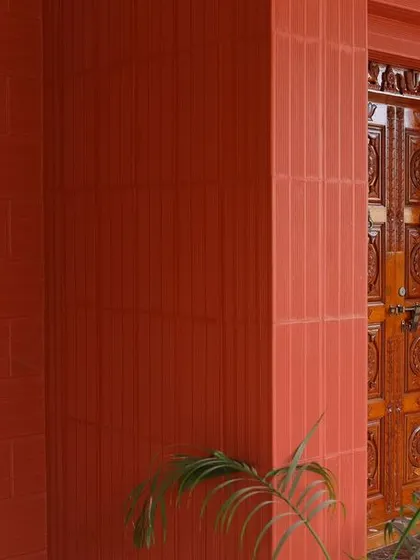 A close-up of the Porotherm brick facade and the layered entrance design, showcasing the texture and warmth of the materials used.
