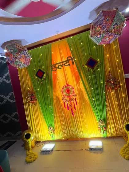 A wide view of the Haldi setup, including the floor lighting I use to illuminate the backdrop and the decorative pots with marigold flowers.