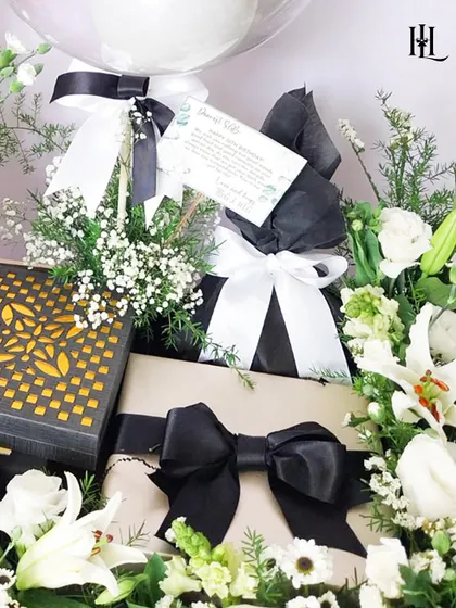 Another detail of the 30th birthday hamper, showing the beautifully wrapped gifts with black and white ribbons, nestled among fresh flowers. This highlights the care and attention I put into the presentation of every single item.