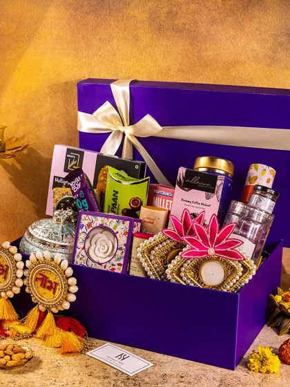A jewel-toned purple hamper box for Diwali, showcasing a variety of products with elegant ribbon and festive props.