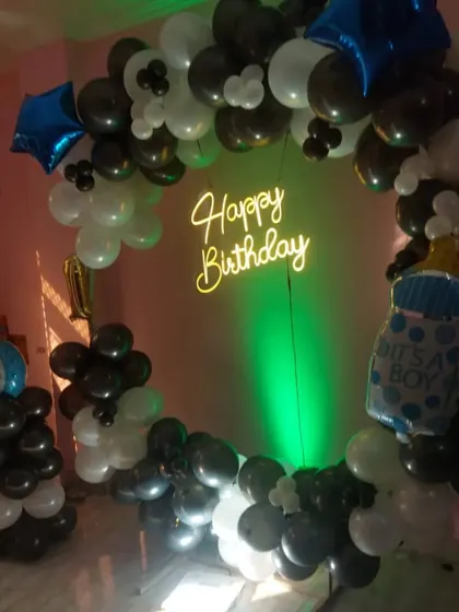 The 'It's a Boy' first birthday setup, shown with green uplighting to add a pop of color to the balloon arrangement.