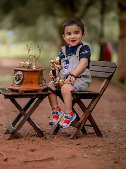 This little one is all smiles, holding the receiver like a trophy. These playful interactions are the heart of a successful and fun baby photoshoot.